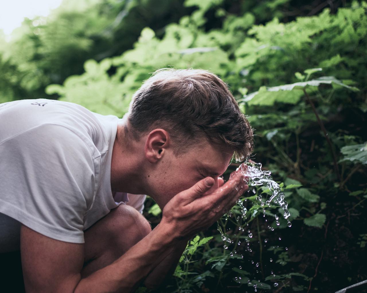 Man Splashing Face With Water